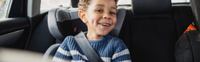Little boy sitting in back seat of car