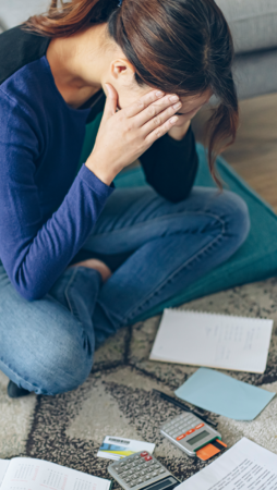 Woman Showing Signs Of Stress From Looking at Bills.